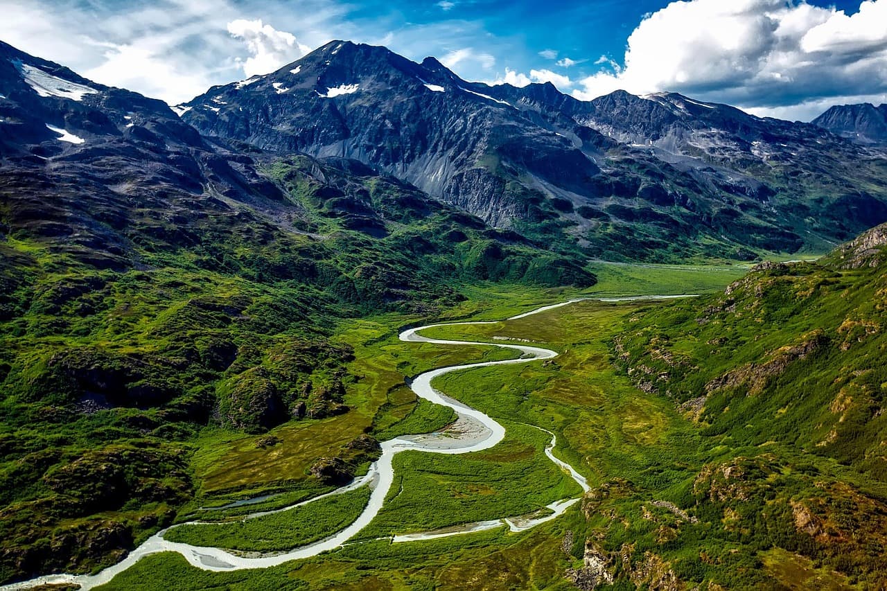 Aerial view of river flowing through Alaska's mountainous landscape