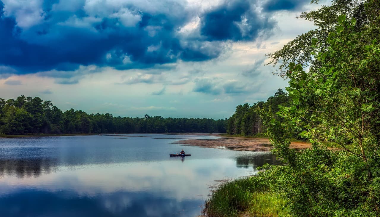 Serene rowboat on Basto Lake in New Jersey's Pine Barrens at sunset
