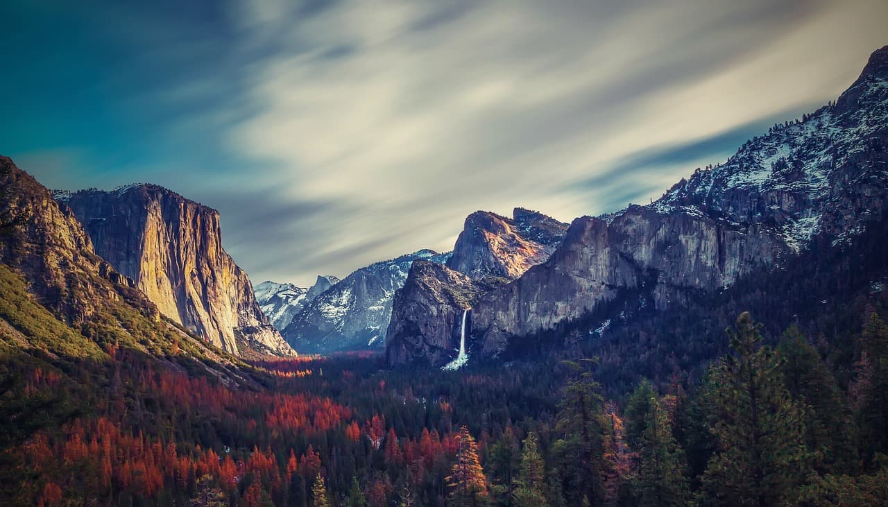 Yosemite Valley in California with waterfall and cliffs surrounded by autumn forest