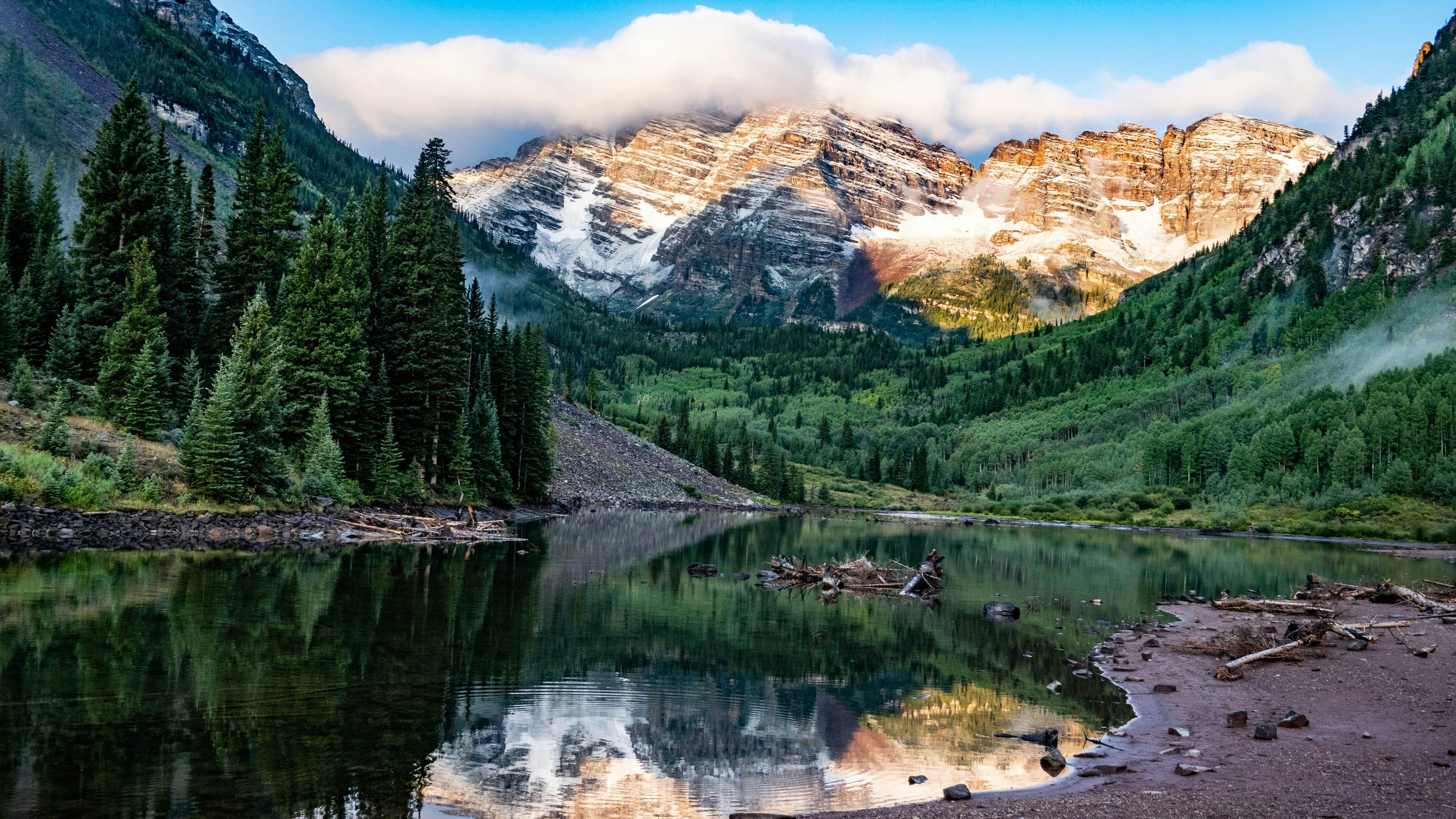Scenic Colorado mountainside camping spot near Aspen, surrounded by pine trees and rocky terrain
