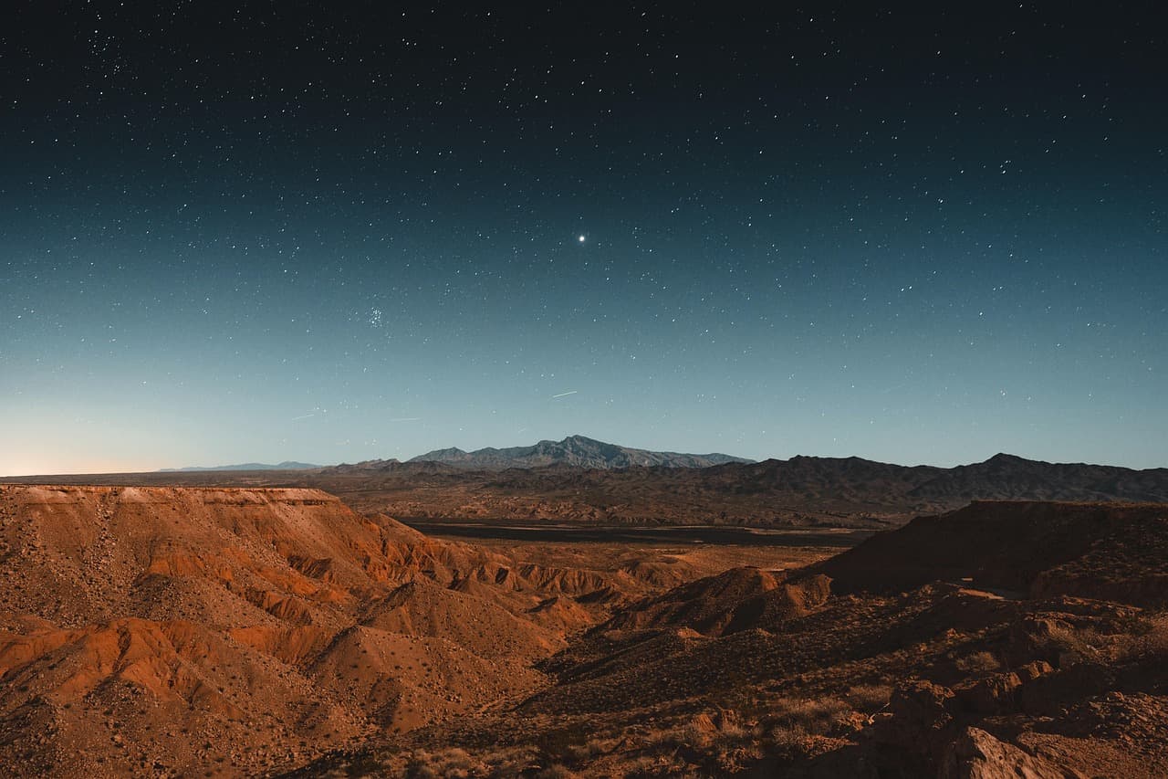 Nevada desert night sky with stars shining over mountainous terrain